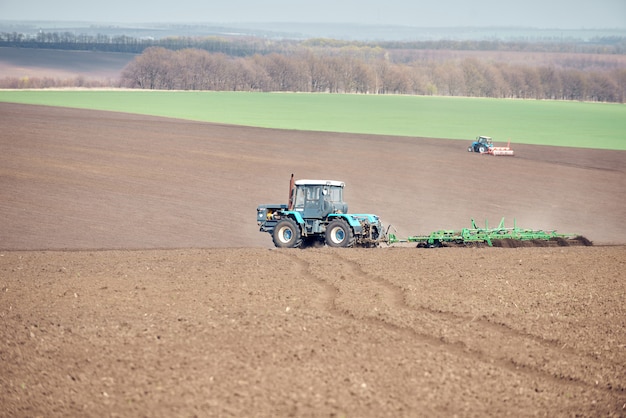 A tractor plowing and sowing in the field