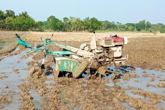 Tractor or power tiller the field is plowed with modern farmer concept