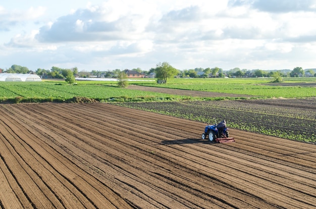 A tractor rides on a farm field.