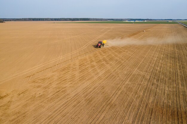 Tractor sows wheat in the field top view