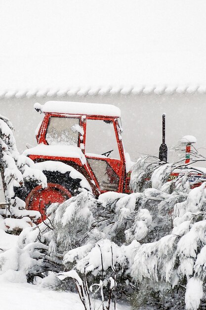 Tractor stopped under a heavy snowstorm.