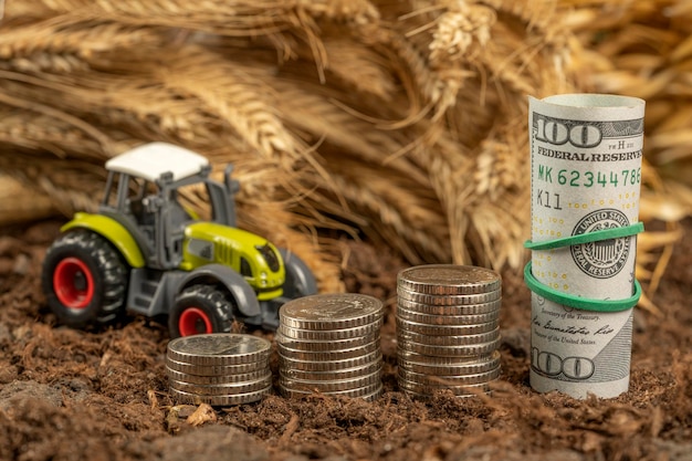 Tractor with money on the background of spikelets of wheat Export of grain and agriculture Rising prices for agricultural products