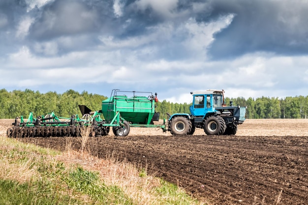 Tractor works in the field for sowing