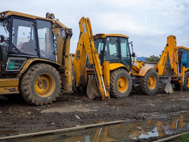 Tractoren met emmers in de modder Rode tractoren op de parkeerplaats Werktechniek zonder actie