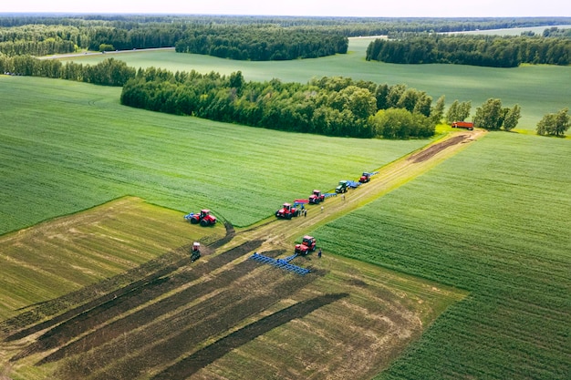 Tractoren met ploeg op grond cultiveren tractor bowlingveld drone weergave Gecultiveerde plant bodembewerking Landbouwtractor op veldteelt Trekker schijveneg op ploegen boerderij veld