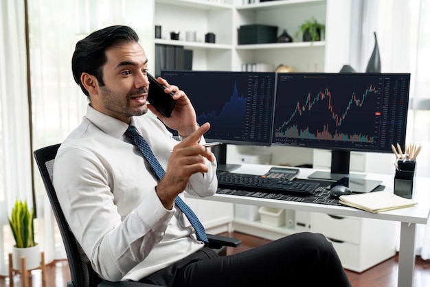 Trader calling to consultant or partner with two stock exchange screen Surmise