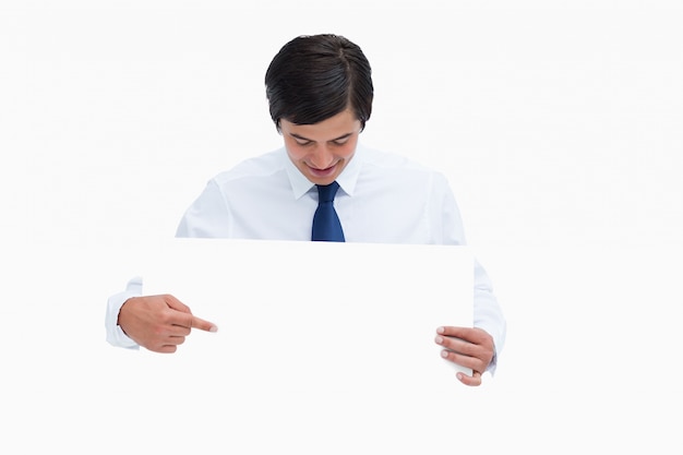 Tradesman pointing and looking at blank sign in his hands