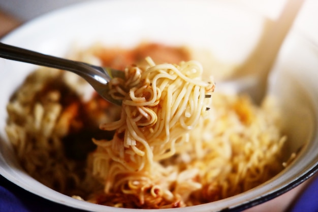 Tradition Thai food Hot and spicy Seafood instant noodle in white bowl on wooden floor background