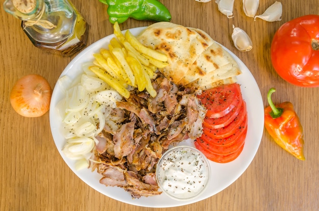 Traditiona Griekse pitabroodjes met vlees, gebakken aardappelen, tomaat, ui