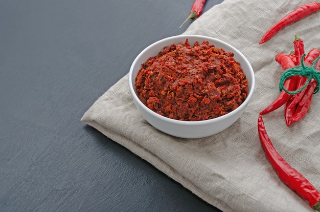 Harissa di salsa di peperoncino piccante tradizionale adjika. tunisia, cucina georgiana e araba. orientamento orizzontale. spazio per il testo.