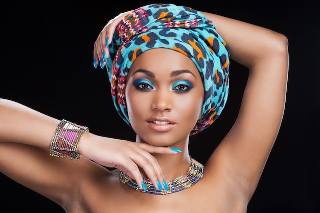 In traditional African style. Beautiful African woman in headscarf and jewelry 