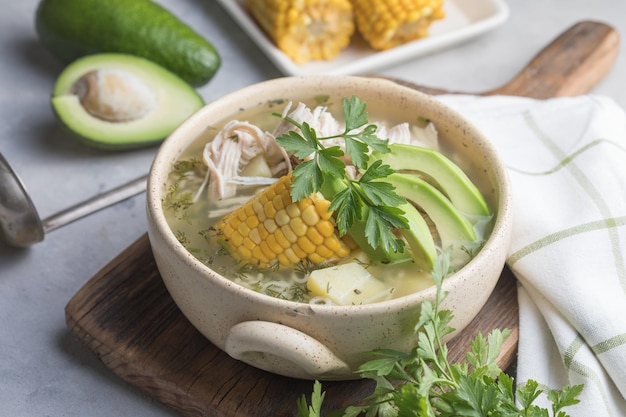 Traditional Ajiaco Colombiano - Colombian Soup with potato, chicken, avocado