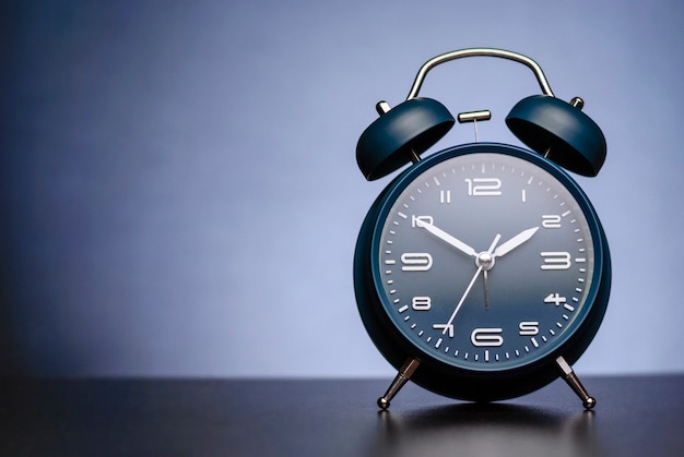 Traditional alarm clock with bells on blue