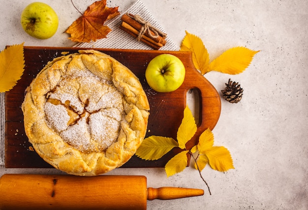 Фото Традиционный американский яблочный пирог на деревянной доске, вид сверху.