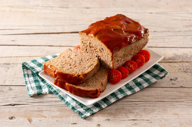 Traditional American meatloaf with ketchup on rustic wooden table