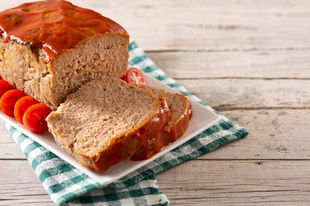 Traditional American meatloaf with ketchup on rustic wooden table