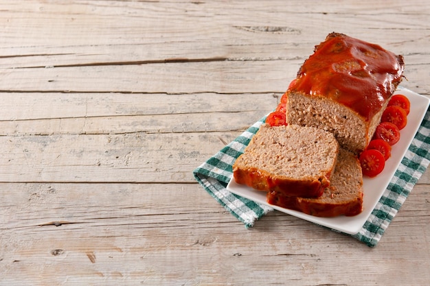 Traditional American meatloaf with ketchup on rustic wooden table