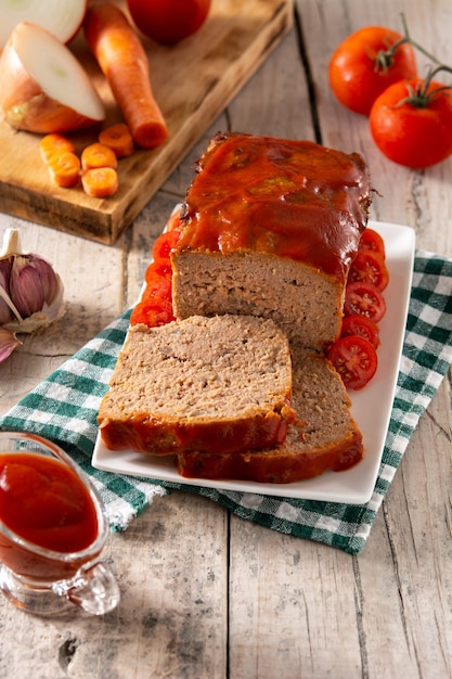 Traditional American meatloaf with ketchup on rustic wooden table