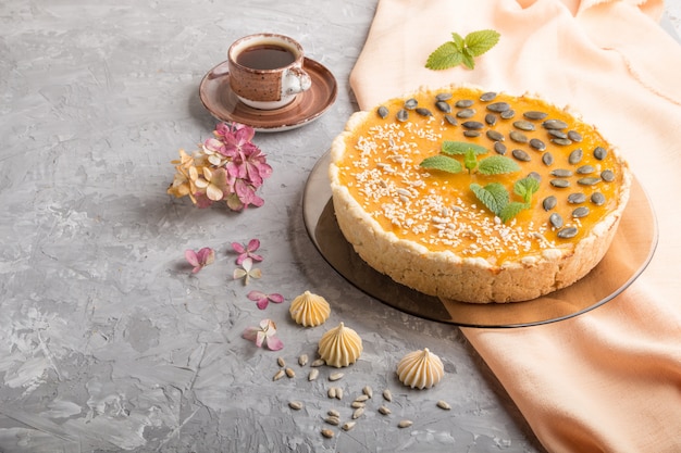 Traditional american sweet pumpkin pie decorated with mint, sesame and pumpkin seeds. side view, copyspace.