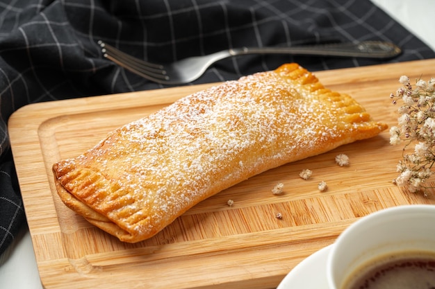 Traditional apple strudel on wooden board close up