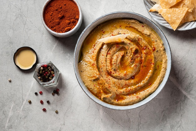 Traditional arabian eggplant dip baba ganoush with herbs and smoked paprika on light background Eggplant hummus Babaganush or eggplant caviar Baked eggplant Turkish eggplant dip