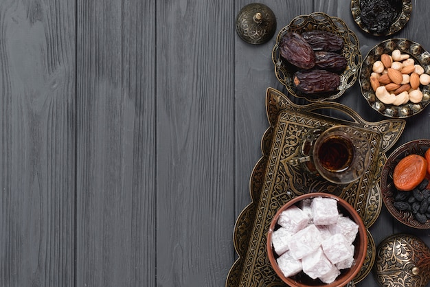 Photo traditional arabic ramadan tea; lukum; dried fruits and nuts on wooden plank