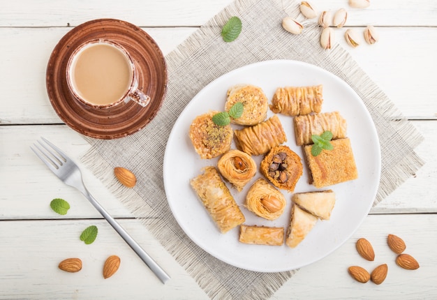 전통적인 아랍 과자 (kunafa, baklava)와 커피 한 잔. 상위 뷰를 닫습니다.