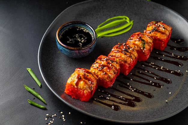 Traditional Asian rolls and sushi with soy sauce and wasabi served on a dark background