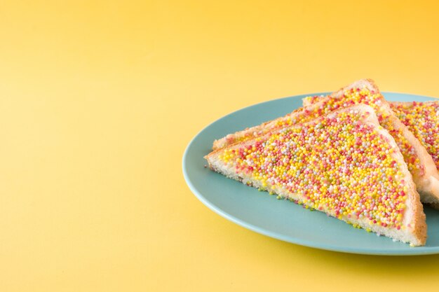 Traditional Australian fairy bread on yellow background copy space