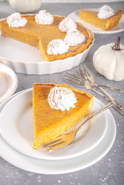 Traditional Autumn Pumpkin Pie. Homemade American Pumpkin pie topped with Whipped Cream.