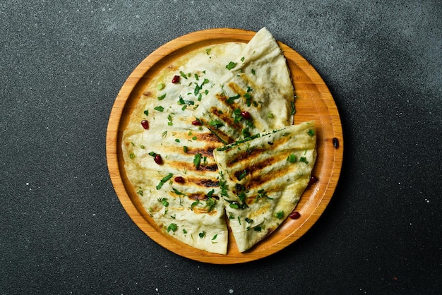 Foto cucina tradizionale azera pane piatto con erbe e carne kutaby qutab kutab spazio libero per il testo su uno sfondo scuro