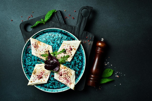 Traditional Azeybarzhan Burum pita bread and greens Free space for text On a dark background