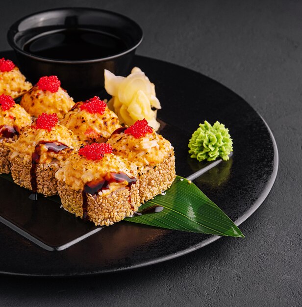 Traditional baked japanese sushi on black plate