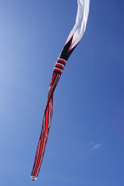 Traditional bali kite with a very large size and long tail is flying on the sanur bali indonesia