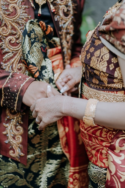 伝統的なバリの文化的なカップルが手をつなぐ