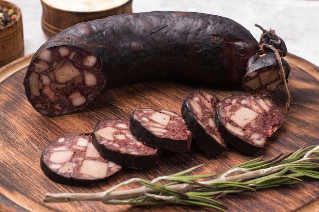 Traditional blood sausage cut into wedges on a wooden board.