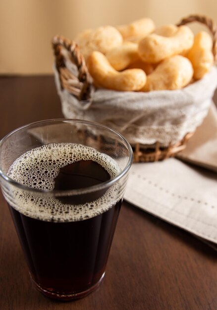 Foto caffè tradizionale brasiliano in un bicchiere americano coppa tipica del brasile polvilho biscotto su cestino sullo sfondo