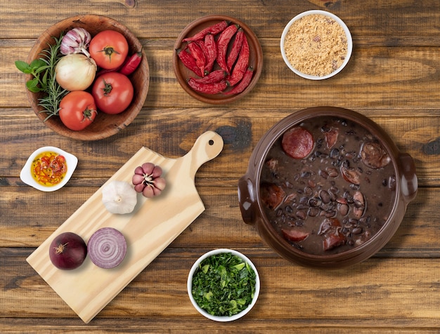 Traditional brazilian feijoada with ingredients, kale and manioc flour.