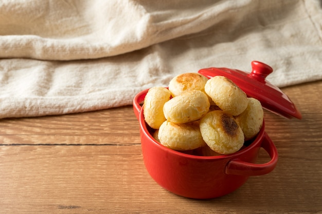 Traditional Brazilian Snack Cheese Bread in a rustic red cooking pot