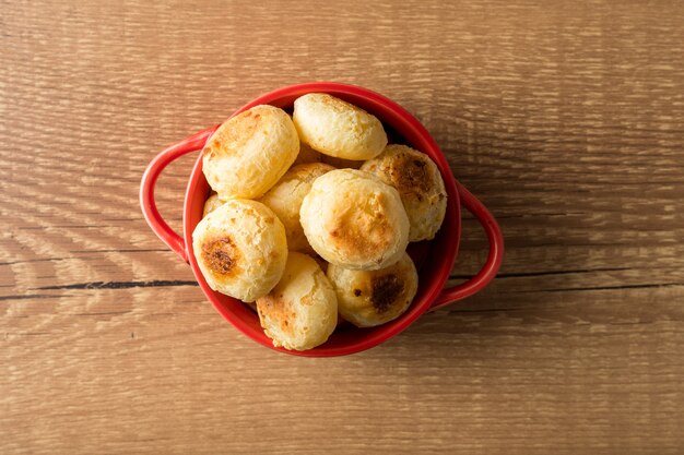 Traditional Brazilian Snack Cheese Bread in a rustic red cooking pot