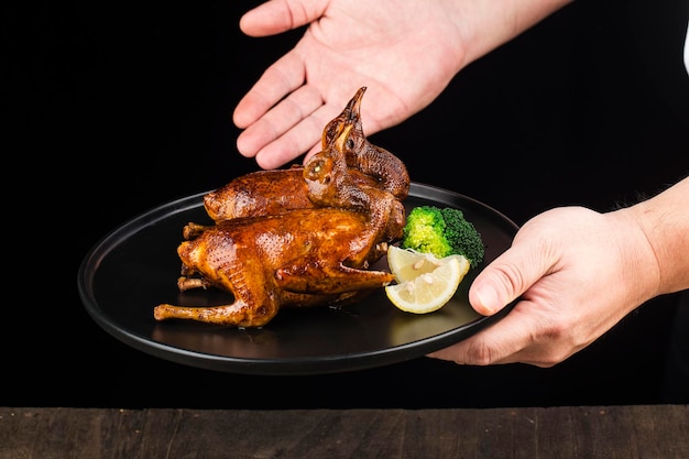 Traditional Cantonese roast pigeon on a and white porcelain plate