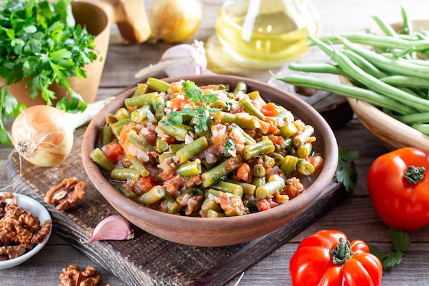 Photo traditional caucasian georgian lobio of green beans with vegetables and tomato, selective focus