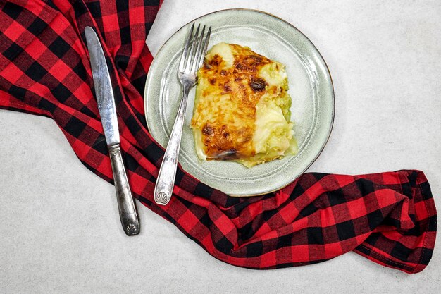 Traditional chicken shepherd pie offered as closeup in a rustic ceramic modern design plate