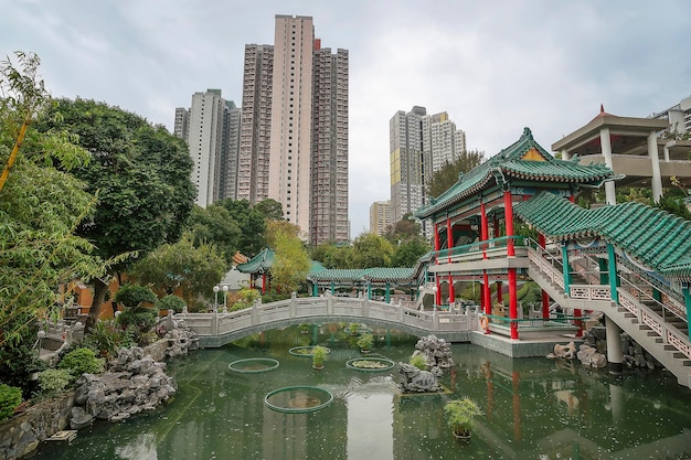 Parco giardino cinese tradizionale a hong kong con piscina e grattacielo intorno