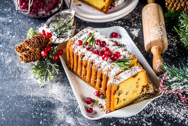 Traditional christmas baking Festive Xmas fruitcake with dryed fruits liquer and cranberry decor Homemade fruitcake on Chritmas decorated background