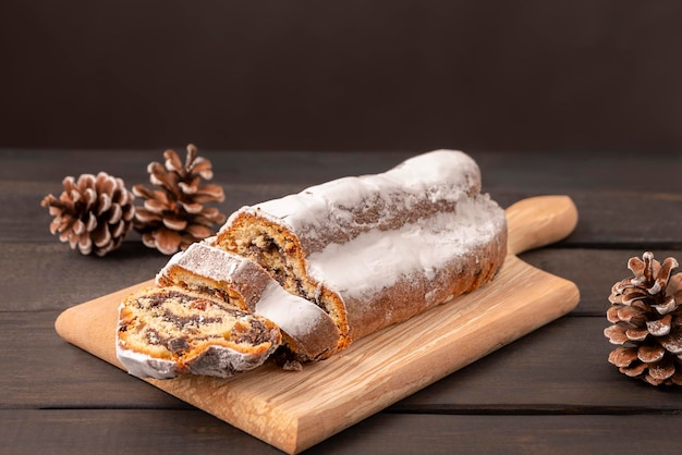 Traditional Christmas cake Stollen on dark wooden background