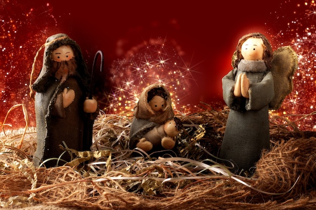 伝統的なクリスマスの装飾。キリスト降誕のシーン。ライトと赤い背景。