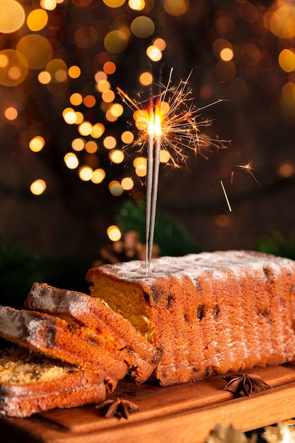 お祝いのクリスマステーブルに線香花火で飾られた伝統的なクリスマスフルーツケーキ