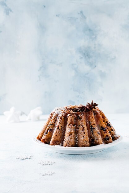 Traditional Christmas fruit cake, pudding on white plate. Top view. Copy space.