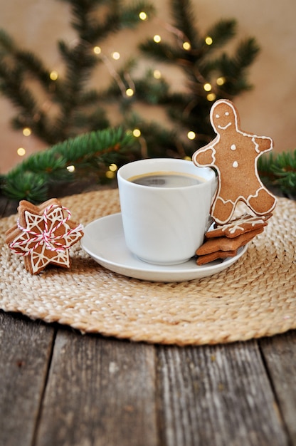 Tradizionale glassa di zucchero di pan di zenzero di natale a forma di omino divertente e una tazza di caffè espresso caldo